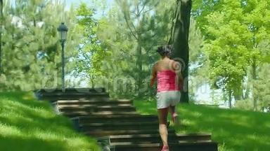 女人缓慢地跑上楼梯。 在公园楼梯上奔跑的女孩